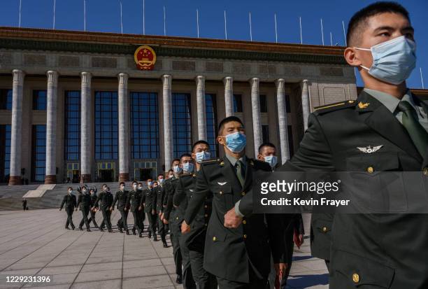Chinese soldiers from the People's Liberation Army wear protective masks as they march after a ceremony marking the 70th anniversary of China's entry...