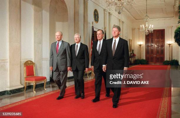 President Bill Clinton walks with former US Presidents Gerald Ford , Jimmy Carter and George Bush at the White House during the signing of side...