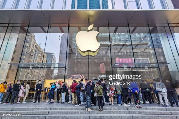 People wait outside an Apple store as the new iPhone 12 series launches in Shanghai on October 23, 2020. / China OUT