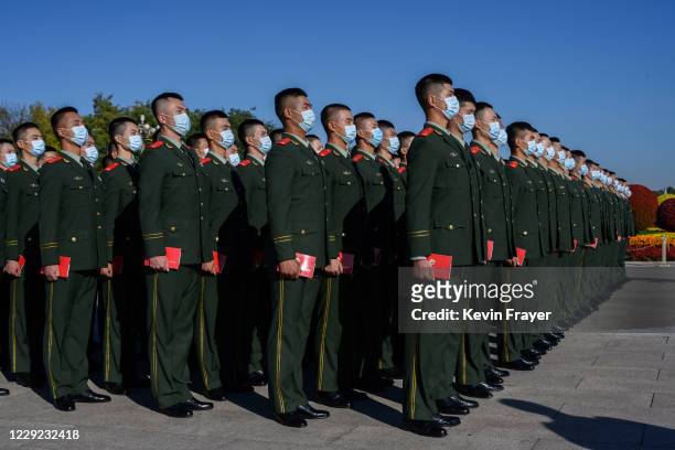 Chinese soldiers from the People's Liberation Army wear protective masks as they line-up after a ceremony marking the 70th anniversary of China's...