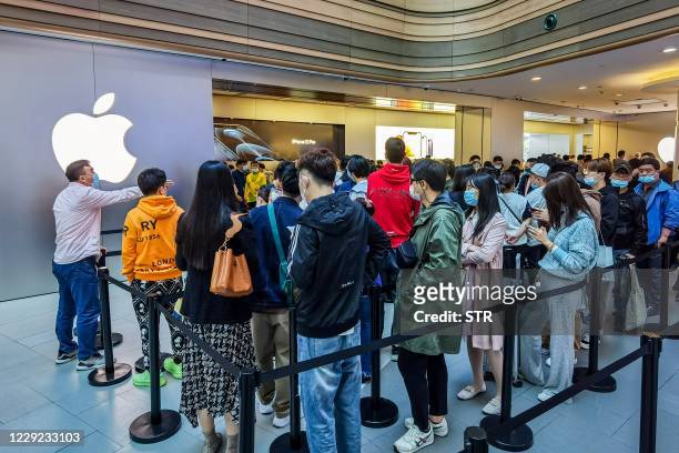 Customers queue to get their reserved iPhone 12 mobile phones at an Apple store in Shanghai on October 23, 2020. / China OUT