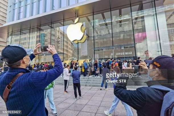 Customers queue to get their reserved iPhone 12 mobile phones at an Apple store in Shanghai on October 23, 2020. / China OUT