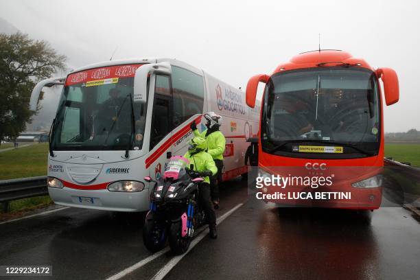 Giro's official regulators chat with bus drivers of cycling teams who drive cyclists to a new start following negotiations about the lenght of the...