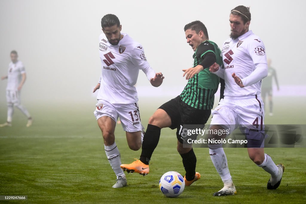 Giacomo Raspadori (C) of US Sassuolo is challenged by...