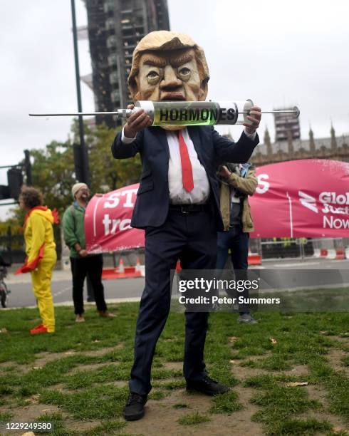Protester dressed as U.S. President Donald Trump joins hundreds of anti-lockdown and anti-Trump protesters holding placards in Parliament Square for...