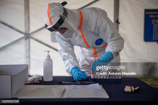 Italian Army health workers collect swabs to check for Covid-19 at a drive-through testing center at Cecchignola Military compound, during the...