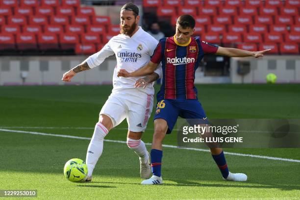 Barcelona's Spanish midfielder Pedri challenges Real Madrid's Spanish defender Sergio Ramos during the Spanish League football match between...