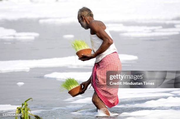 Man heads to immerse items used as part of Durga Puja rituals in the River Yamuna, on October 24, 2020 in Noida, India.