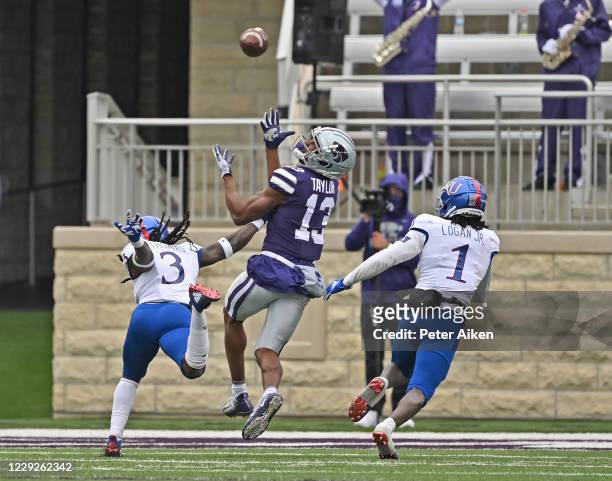 Wide receiver Chabastin Taylor of the Kansas State Wildcats makes an over the shoulder catch against safety Ricky Thomas of the Kansas Jayhawks and...