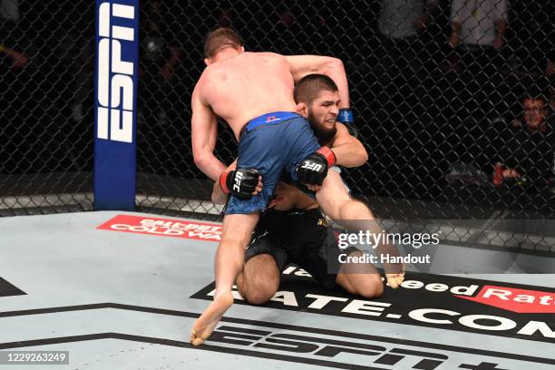 In this handout image provided by UFC, Khabib Nurmagomedov of Russia takes down Justin Gaethje in their lightweight title bout during the UFC 254...