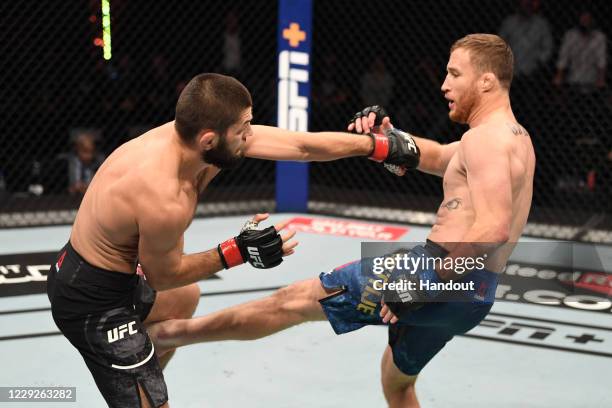 In this handout image provided by UFC, Justin Gaethje kicks Khabib Nurmagomedov of Russia in their lightweight title bout during the UFC 254 event on...
