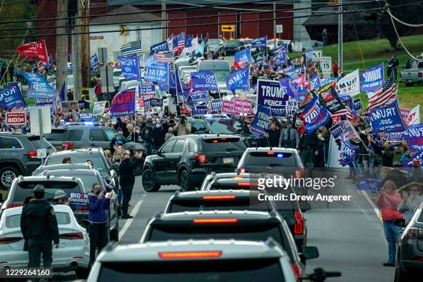 Supporters of President Donald Trump line the road as the motorcade for Democratic presidential nominee Joe Biden makes its way to a drive-in...
