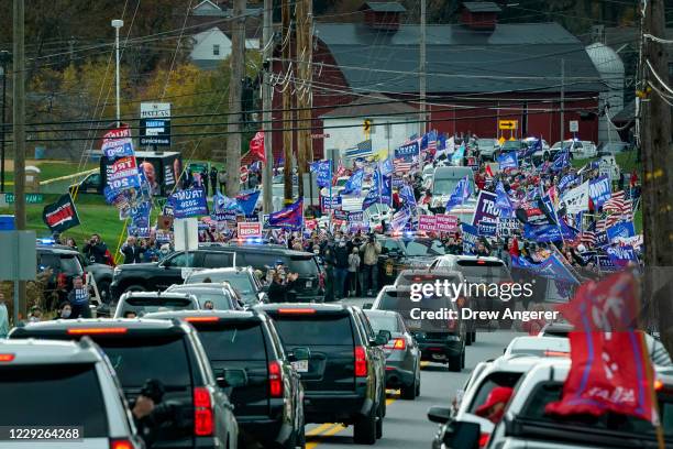 Supporters of President Donald Trump line the road as the motorcade for Democratic presidential nominee Joe Biden makes its way to a drive-in...