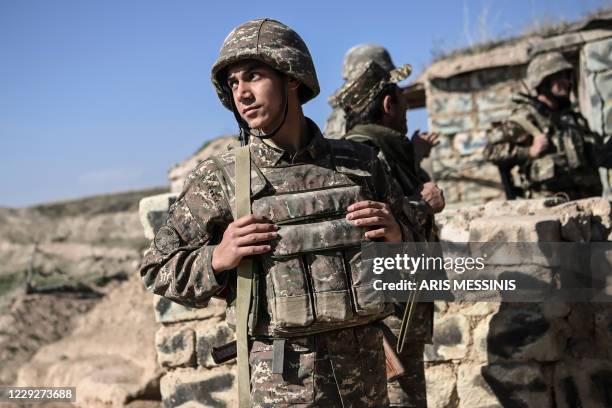 Armenian soldiers stand as troops hold positions on the front line on October 25 during the ongoing fighting between Armenian and Azerbaijani forces...