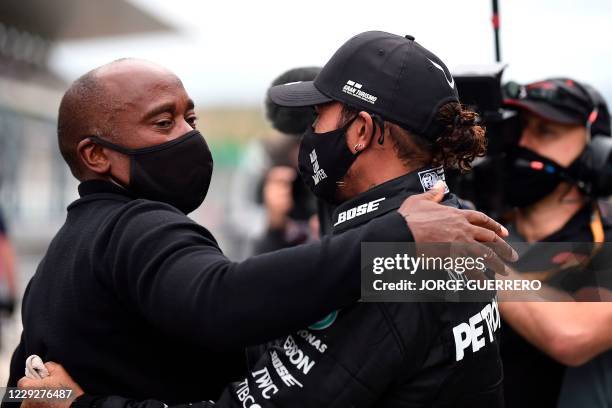 Mercedes' British driver Lewis Hamilton celebrates his victory with his father Anthony in the parc ferme after the Portuguese Formula One Grand Prix...