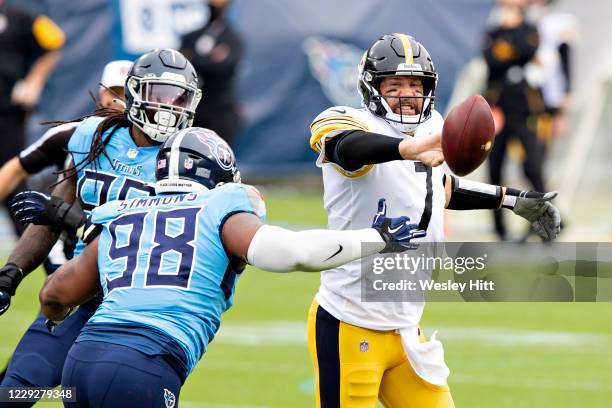 Ben Roethlisberger of the Pittsburgh Steelers throws a shuffle pass in the first half while under pressure from Jeffery Simmons of the Tennessee...