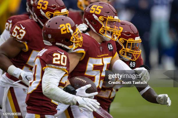 Cole Holcomb of the Washington Football Team celebrates with teammates after making an interception against the Dallas Cowboys during the first half...