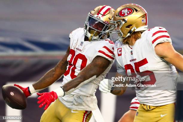 Jeff Wilson reacts with George Kittle of the San Francisco 49ers after scoring a touchdown during a game against the New England Patriots on October...