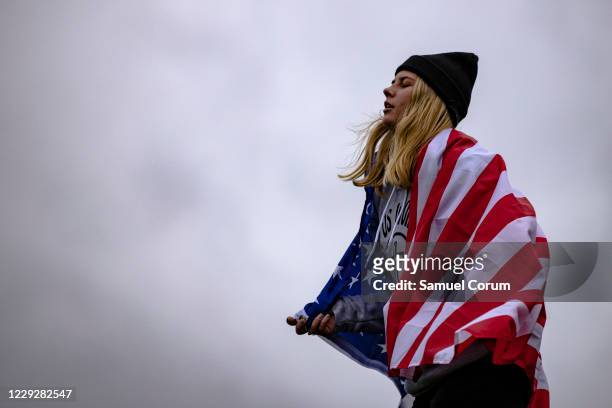 Amanda Finger, from Ashland, Ohio, dances with an American flag as she worships during a concert by evangelical musician Sean Feucht on the National...