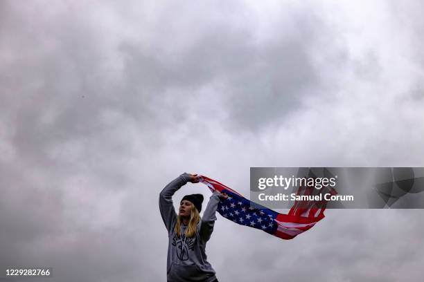Amanda Finger, from Ashland, Ohio, dances with an American flag as she worships during a concert by evangelical musician Sean Feucht on the National...