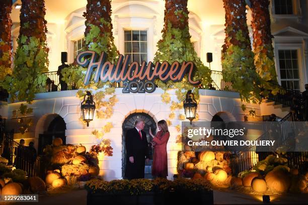 President Donald Trump and First Lady Melania Trump pose ahead of greeting trick or treaters during a Halloween celebration at the White House in...