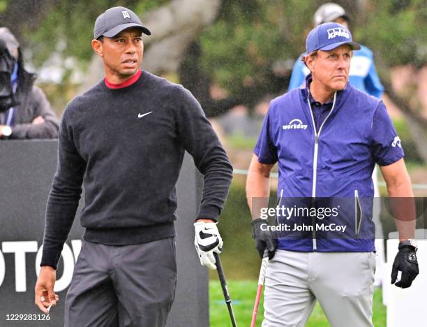Tiger Woods watches his tee shot on the 10th hole while Phil Mickelson gets ready to hit during the final round of the ZOZO Championship at Sherwood...
