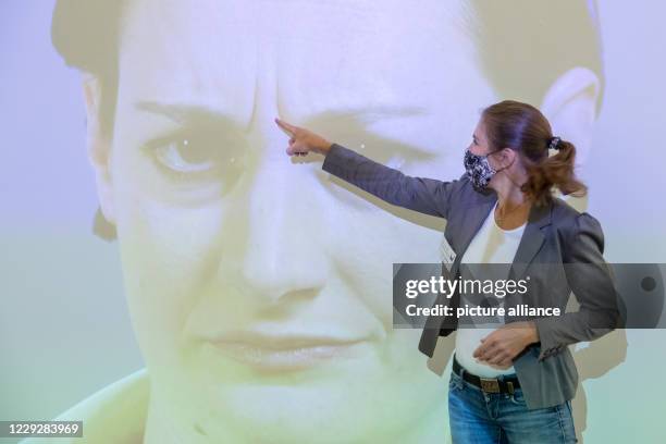 October 2020, Bavaria, Nuremberg: Luna Mittig explains details of facial expressions and gestures on a video installation in the Museum of...