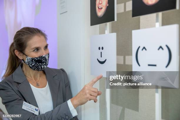 October 2020, Bavaria, Nuremberg: Luna Mittig explains details of facial expressions and gestures on an installation in the Museum for Communication....