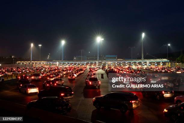 Cars line up to cross the US/Mexico border to San Diego at San Ysidro port of entry, in Tijuana, Baja California state, Mexico, on October 6, 2020. -...