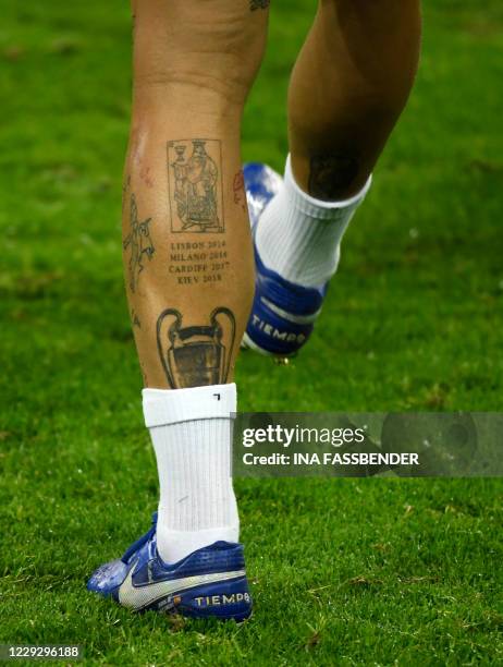 The leg of Real Madrid's Spanish defender Sergio Ramos shows a tattoo of the Champions League trophy during the training session on the eve of the...