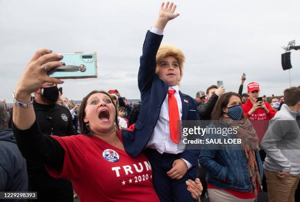 Supporter and her child dressed as the president, gestures as US President Donald Trump speaks during a Make America Great Again campaign rally at...