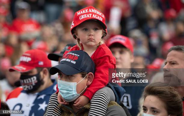 Child wearing a MAGA hat looks around as US President Donald Trump speaks during a Make America Great Again campaign rally at Altoona-Blair County...