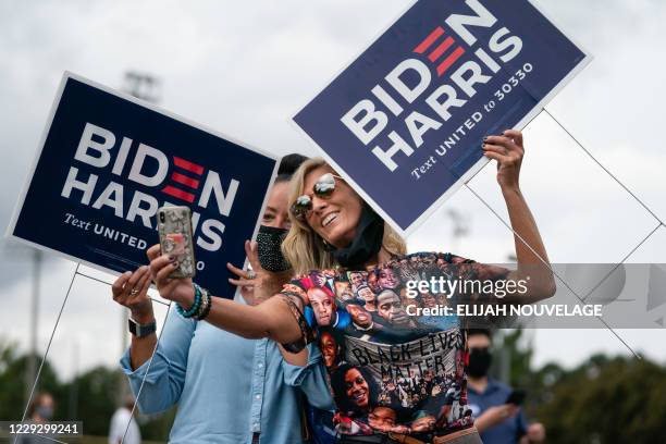 Two women holding Biden/Harris lawns signs take a selfie at a rally with Democratic Senate candidates Rev. Raphael Warnock and Jon Ossoff on October...