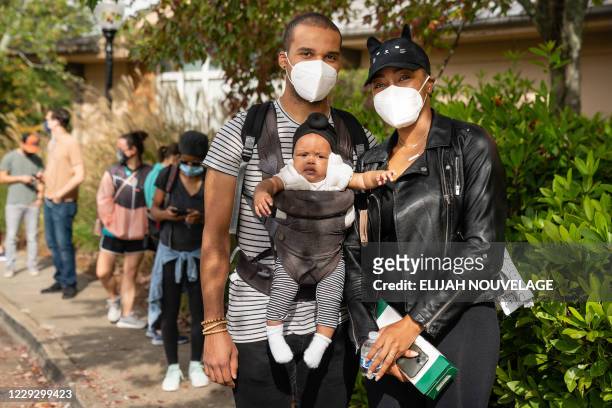 Jamal and Michelle Jenkins wait in line with their four-month-old daughter Asia to cast their ballots at an early voting location in the Smyrna...