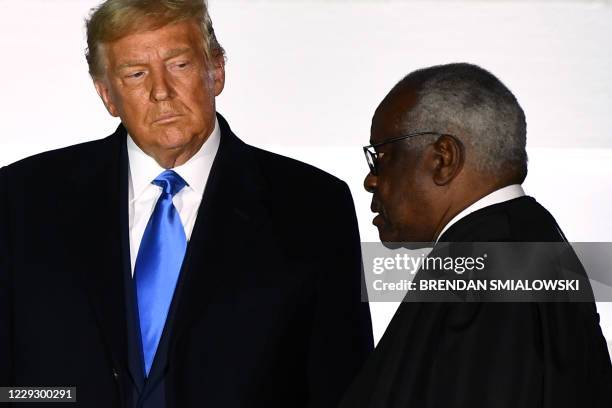 President Donald Trump watches as Supreme Court Associate Justice Clarence Thomas swears in Judge Amy Coney Barrett as a US Supreme Court Associate...