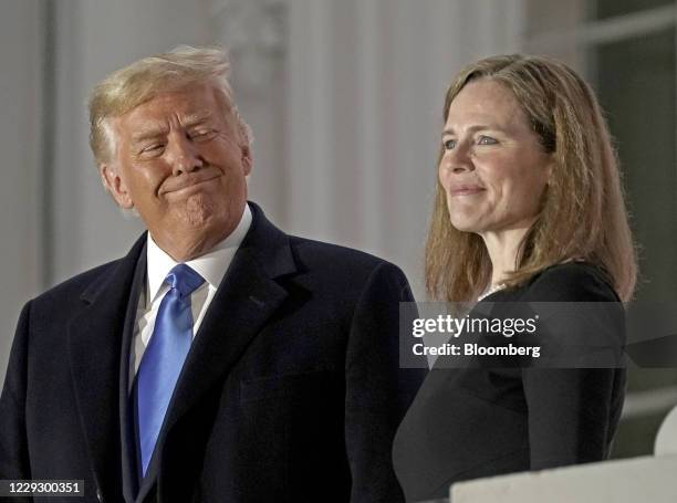 President Donald Trump, left, and Amy Coney Barrett, associate justice of the U.S. Supreme Court, stand on a balcony during a ceremony on the South...