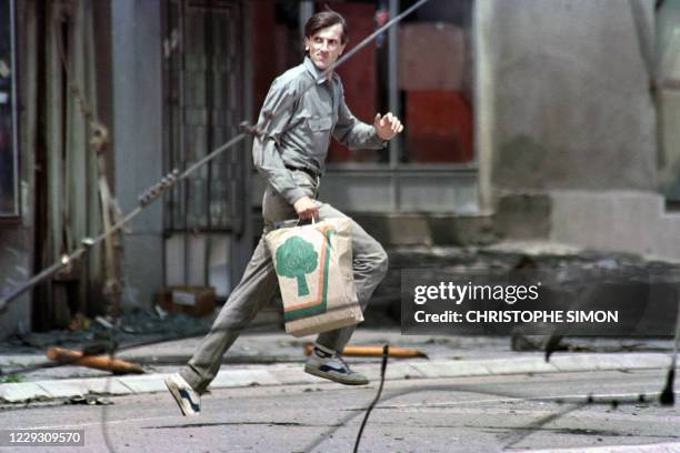Local resident runs in a street in Sarajevo on June 19, 1992. A two-day-old cease fire in this besieged city collapsed June 17 as heavy artillery,...