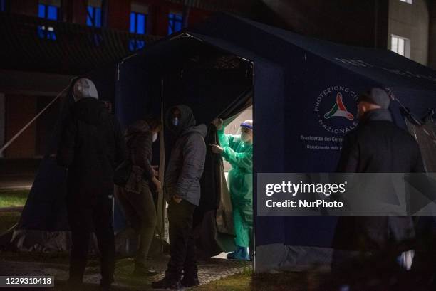 Nurse invites the next patient to sit in the civil protection tent to take the swab Schiavonia, October 26 Italy. After the increase in the contagion...