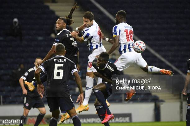 Olympiakos' Portuguese defender Ruben Semedo jumps for the ball with FC Porto's Serbian midfielder Marko Grujic and FC Porto's Congolese defender...