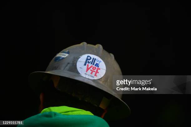 Construction worker wears a " Pull Up & Vote" sticker on his hard hat as voters queue outside of Philadelphia City Hall to cast their early voting...