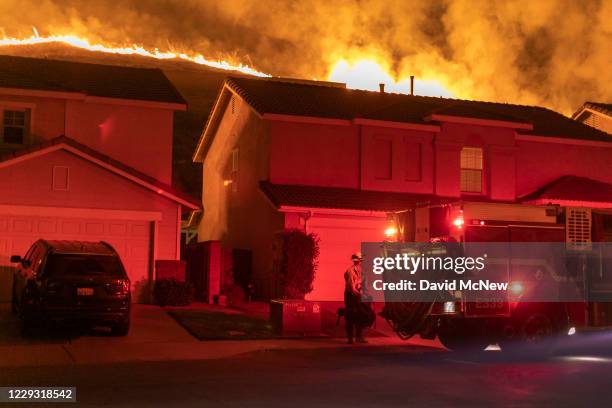 Flames come close to houses during the Blue Ridge Fire on October 27, 2020 in Chino Hills, California. Strong Santa Ana Winds gusting to more than 90...