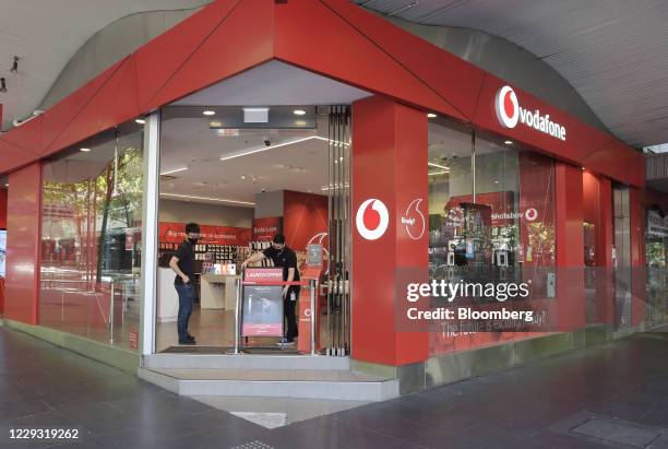 Shop assistants place a sign at the entrance to a Vodafone store in Melbourne, Australia, on Wednesday, Oct 28, 2020. As countries across the globe...