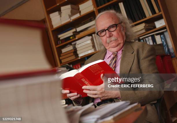 Alain Rey, directeur éditorial des Dictionnaires Le Robert, lit la dernière édition de son dictionnaire dans son bureau, le 18 février 2002 à Paris....