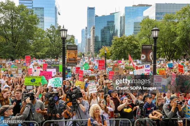 Protesters gather at the Queen's Park while holding placards expressing their opinions during the demonstration. Thousands marched in the city of...