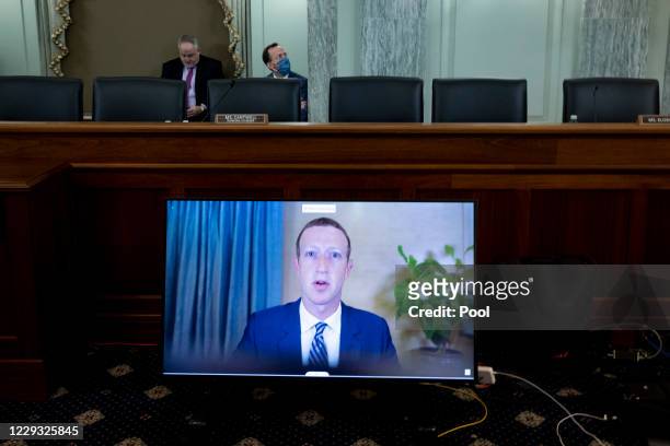 Of Facebook Mark Zuckerberg appears on a monitor as he testifies remotely during the Senate Commerce, Science, and Transportation Committee hearing...