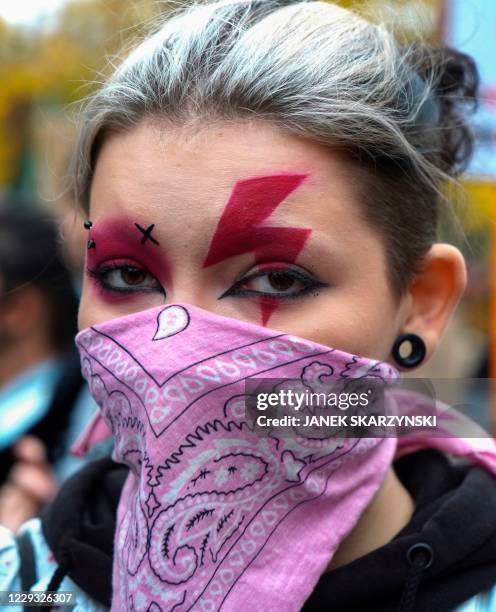 Woman sports a lightning bolt painted over her eyes as she attends a demonstration against the tightening of Poland's already restrictive abortion...