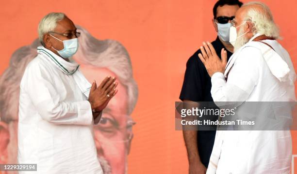 Prime Minister Narendra Modi gestures towards Bihar Chief minister Nitish Kumar during a campaign rally to garner support for NDA candidates in Bihar...