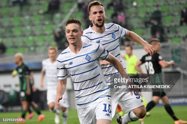 Dynamo Kiev's Ukrainian forward Viktor Tsygankov celebrates after scoring a penalty with Dynamo Kiev's Polish defender Tomasz Kedziora during the...