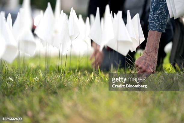 Volunteers plant white flags representing the number of Americans who have died of Covid-19 at the D.C. Armory Parade Grounds in Washington, D.C.,...
