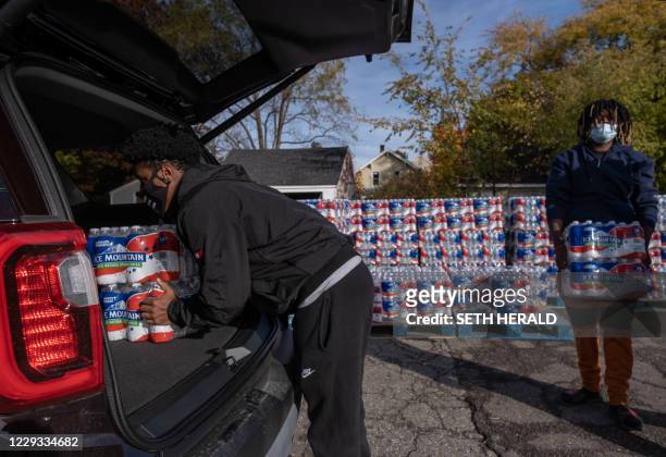 Volunteers help distribute water at Asbury United Methodist Help Center in Flint, Michigan, October 20,2020. - Authorities say Flint's water meets...